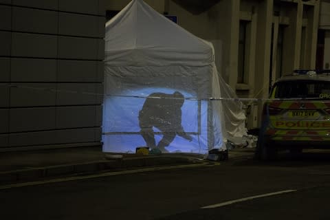 A forensic officer's silhouette is seen through a tent at the scene of a stabbing - Credit: SWNS.com