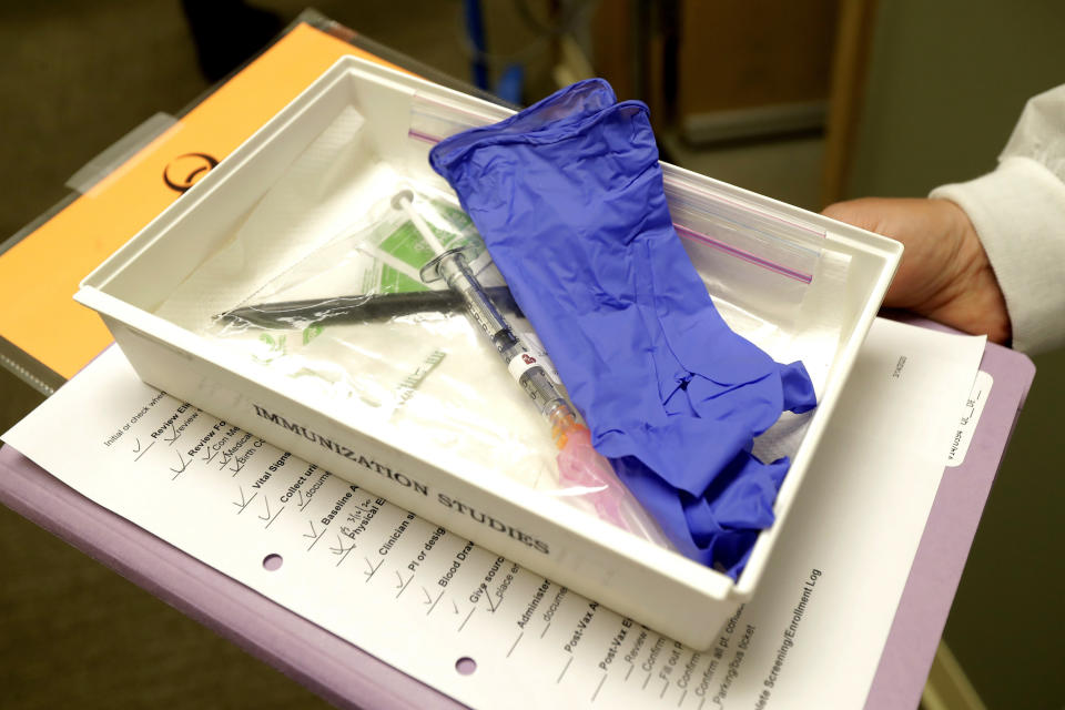 FILE - In this March 16, 2020, file photo, pharmacist Michael Witte holds a tray with a syringe containing a shot that will be used in the first clinical trial of a potential vaccine for COVID-19 at the Kaiser Permanente Washington Health Research Institute in Seattle. An influential scientific panel on Tuesday, Dec. 1, is set to tackle one of the most pressing questions in the U.S. coronavirus epidemic: When the first doses of COVID-19 vaccine become available, who should be at the front of the line for shots? (AP Photo/Ted S. Warren, File)