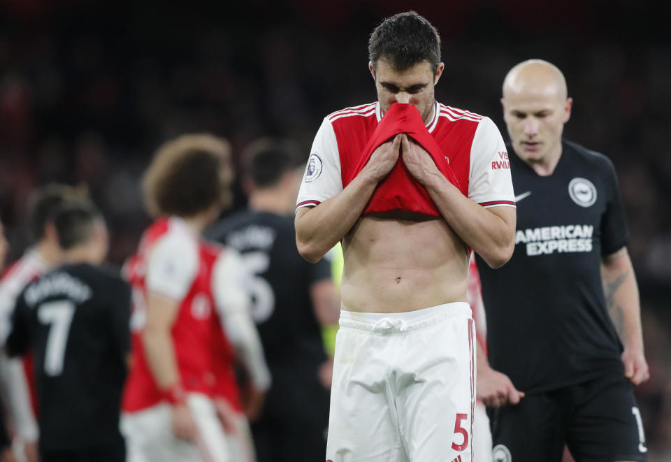 Arsenal's Sokratis Papastathopoulos wipes his face during the English Premier League soccer match between Arsenal and Brighton, at the Emirates Stadium in London, Thursday, Dec. 5, 2019. (AP Photo/Frank Augstein)