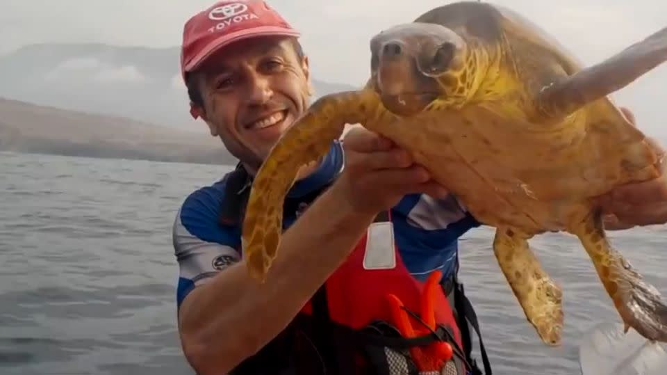 The man kisses the turtle and pauses for a quick photo. Photo: The Weather Channel