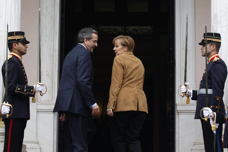 Antonis Samaras, Greece's prime minister, left, greets Angela Merkel, Germany's chancellor, on her arrival at the prime minister's office in Athens, on Friday, April 11, 2014, for a brief visit, a day after the crisis-hit country returned to international bond markets. Greece this week reached a milestone in the recovery from its financial crisis — it successfully tapped bond markets for the first time since 2010, raising 3 billion euros ($4.14 billion) in five-year debt. (AP Photo/Kostas Tsironis/pool)