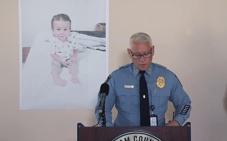 Chatham County Police Chief Jeff Hadley speaks to reporters as he stands in front of a large photo of missing toddler Quinton Simon at a police operations center being used in the search for the boy's remains just outside Savannah, Ga., Tuesday, Oct. 18, 2022. Quinton was reported missing from his home Oct. 5, 2022, by his mother. (WSAV-TV via AP)