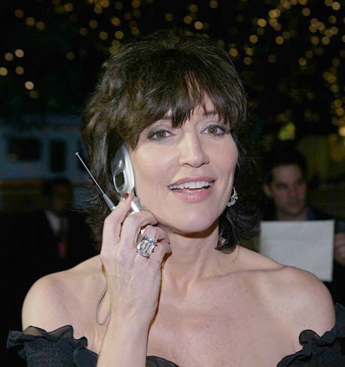 Katey Sagal talking on a flip phone on a red carpet