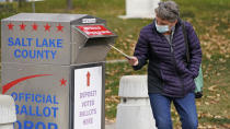 A women inserts her ballot in a ballot drop box Friday, Oct. 23, 2020, in Salt Lake City. (AP Photo/Rick Bowmer)