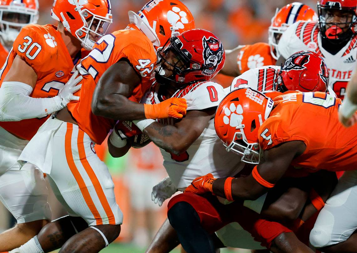 N.C. State running back Demie Sumo-Karngbaye (0) is stopped by Clemson linebacker LaVonta Bentley (42) and defensive end K.J. Henry (5) during the second half of Clemson’s 30-20 victory over N.C. State at Memorial Stadium in Clemson, S.C., Saturday, Oct. 1, 2022.