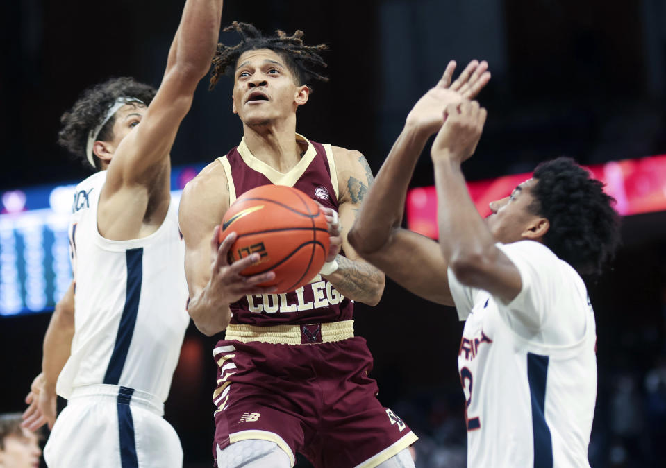 FILE - Boston College guard Makai Ashton-Langford (11) shoots between Virginia forward Kadin Shedrick (21) and Virginia guard Reece Beekman (2) during an NCAA college basketball game in Charlottesville, Va., Tuesday, Feb. 1, 2022. Boston College is hoping continuity leads to more success in the second year under coach Earl Grant. (AP Photo/Andrew Shurtleff, File)