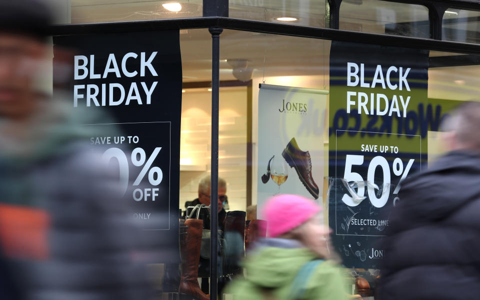 Shops in Canterbury, Kent, display offer posters ahead of Black Friday sales.