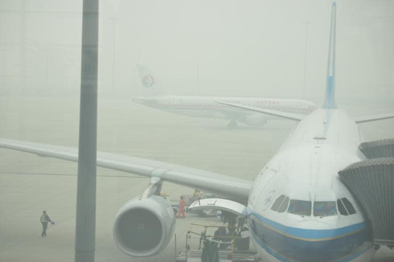 Aircraft are barely visible through thick smog on the tarmac of Hongqiao airport in Shanghai as severe pollution blankets the city on December 6, 2013