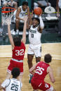 Michigan State's Aaron Henry (0) shoots against Indiana's Trey Galloway (32) and Race Thompson (25) during the second half of an NCAA college basketball game Tuesday, March 2, 2021, in East Lansing, Mich. Michigan State won 64-58. (AP Photo/Al Goldis)