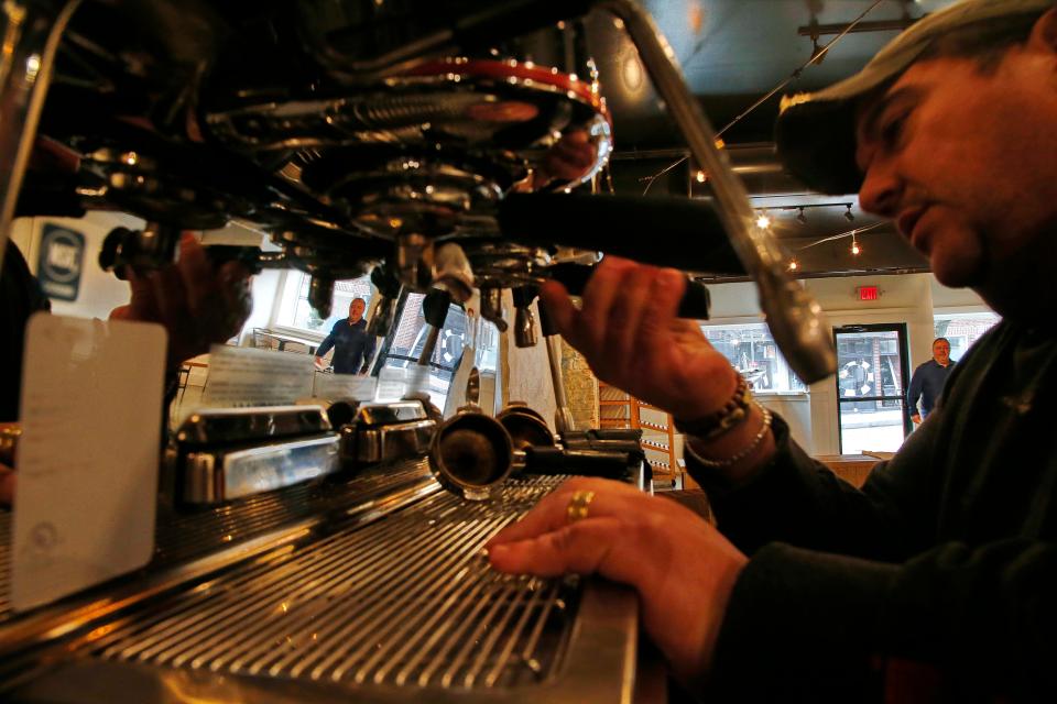 Tom Consol sets up the new espresso machine at the new New Beige restaurant opening next month on Union Street in New Bedford. Reflected on the machine is Al Santos, a co-owner of the restaurant.
