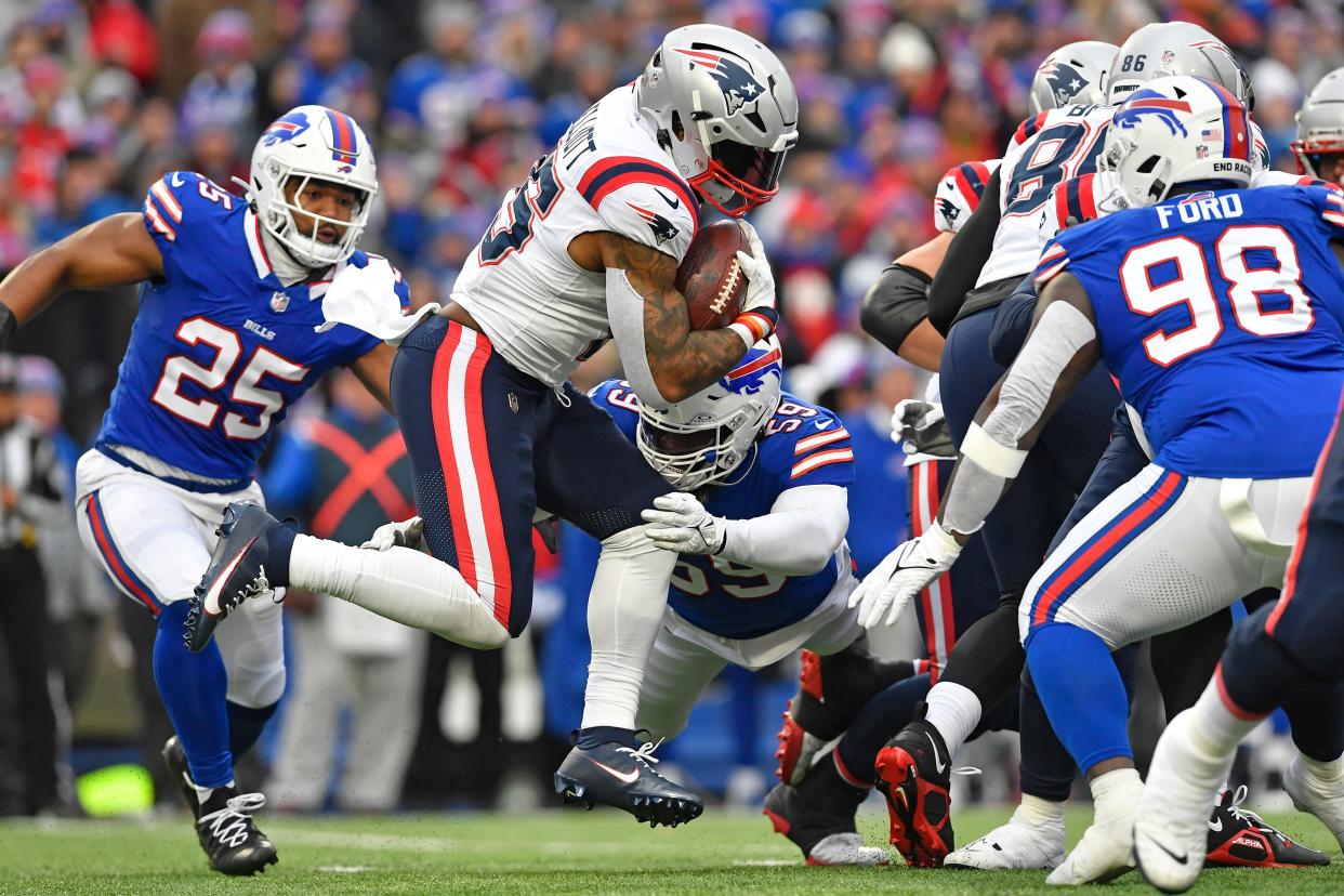 New England Patriots running back Ezekiel Elliott (15) is tackled by Buffalo Bills defensive end Kingsley Jonathan (59) during the first half of an NFL football game in Orchard Park, N.Y., Sunday, Dec. 31, 2023. (AP Photo/Adrian Kraus)
