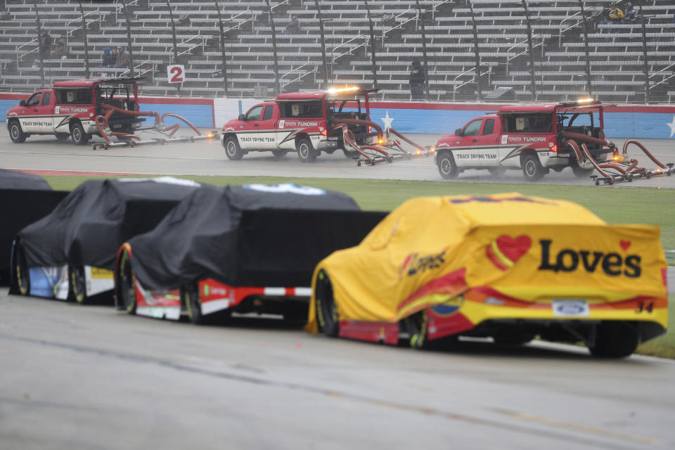 Trucks dry off the track during a red flag delay due to inclement weather during a NASCAR Cup Series auto race at Texas Motor Speedway in Fort Worth, Texas, Sunday, Oct. 25, 2020. (AP Photo/Richard W. Rodriguez)