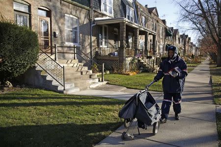 Mail carrier Marissa Ogletree delivers mail in the historic Pullman neighborhood in Chicago November 20, 2014. REUTERS/Andrew Nelles