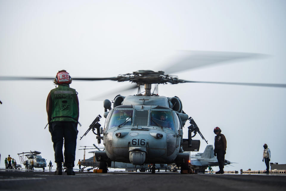 In this photo provided by the U.S. Navy, sailors on board an MH-60S Seahawk helicopter on the flight deck of aircraft carrier USS Ronald Reagan prepare to head to an oil tanker that was attacked off the coast of Oman in the Arabian Sea on Friday, July 30, 2021. An attack on an oil tanker linked to an Israeli billionaire killed two crew members off Oman in the Arabian Sea, authorities said Friday, marking the first fatalities after years of assaults targeting shipping in the region. (Mass Communication Specialist 2nd Class Quinton A. Lee/U.S. Navy, via AP)