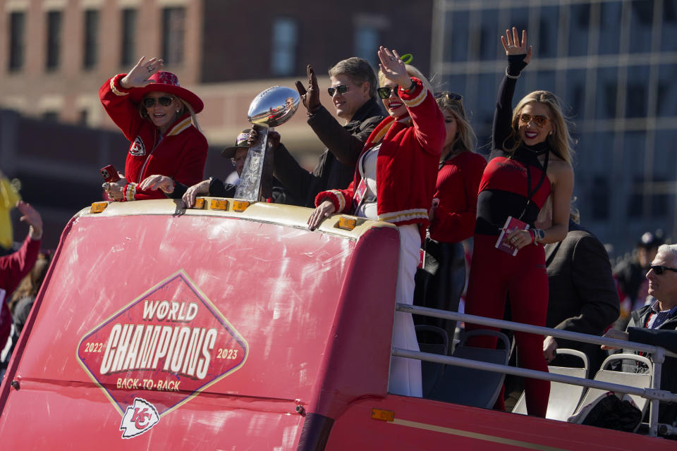 Holding Vince Lombardi Trophy, Kansas City Chiefs owner Clark Hunt waves with his wife Tavia Hunt, and daughter Gracie Hunt, right, as the Kansas City Chiefs celebrate during their victory parade in Kansas City, Mo., Wednesday, Feb. 14, 2024. The Chiefs defeated the San Francisco 49ers Sunday in the NFL Super Bowl 58 football game. (AP Photo/Ed Zurga)