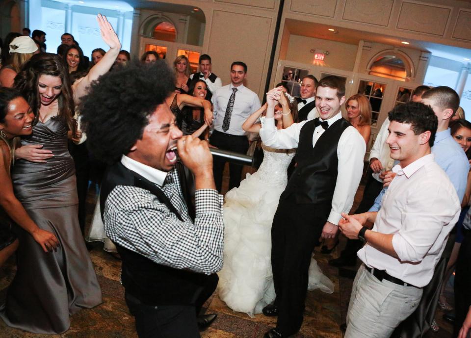 This Nov. 23, 2012 photo provided by Alana Mallon shows groom, Jim Mallon, second right, enjoying singer Gedeon McKinney and the Uptown Swing Band he hired through GMS Management for his wedding to his bride, Alana Mallon, during the reception in New Rochelle, New York. Generations ago, planning a wedding was 100 percent the bride's job, but in today's age of gender equity, it's a mere 99 percent. Modern men are more involved than ever. (AP Photo/Alana Mallon, Janie Algeri, VIP Events, LLC)