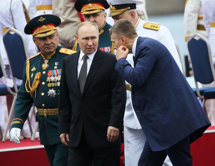 <div class="inline-image__caption"><p>Russian President Vladimir Putin (C) talks to his bodyguard (R) as Defense Minister Sergei Shoigu (L) looks on during the Navy Day Parade on July 31, 2022, in Saint Petersburg, Russia. President Vladimir Putin has arrived to Saint Petersburg to review Main Naval Parade of over 50 military ships on Russia's Navy Day. </p></div> <div class="inline-image__credit">Contributor/Getty Images</div>