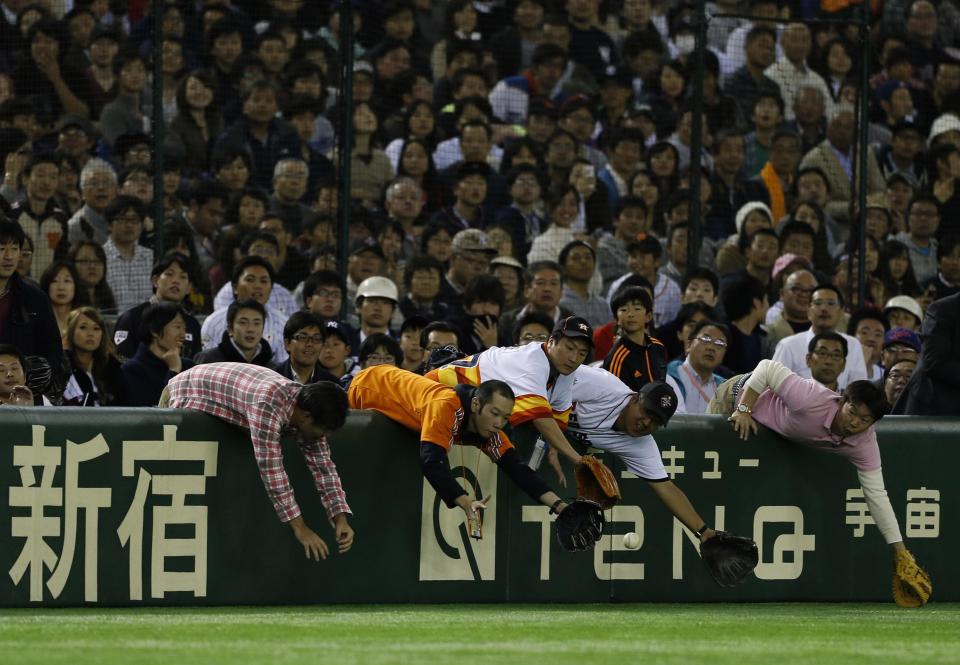 Fans try to catch a foul ball hit by U.S. Major League Baseball (MLB) All-Stars second baseman Jose Altuve of the Houston Astros (not in picture) during the ninth inning of an exhibition baseball game against Japan in Tokyo November 15, 2014. REUTERS/Yuya Shino (JAPAN - Tags: SPORT BASEBALL)