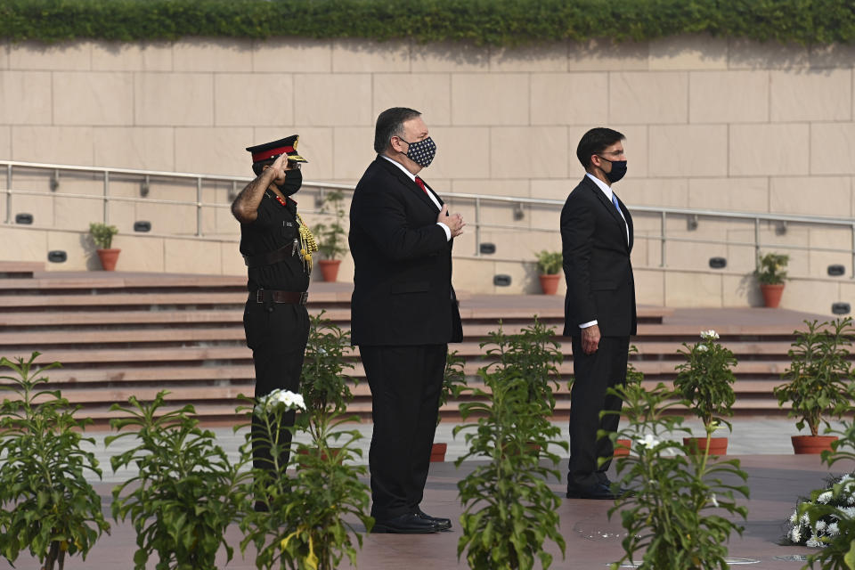 U.S. Secretary of State Mike Pompeo, center, and Secretary of Defence Mark Esper pay their tributes at the National War Memorial in New Delhi, India, Tuesday, Oct. 27, 2020. In talks on Tuesday with their Indian counterparts, Pompeo and Esper are to sign an agreement expanding military satellite information sharing and highlight strategic cooperation between Washington and New Delhi with an eye toward countering China. (Jewel Samad/Pool via AP)