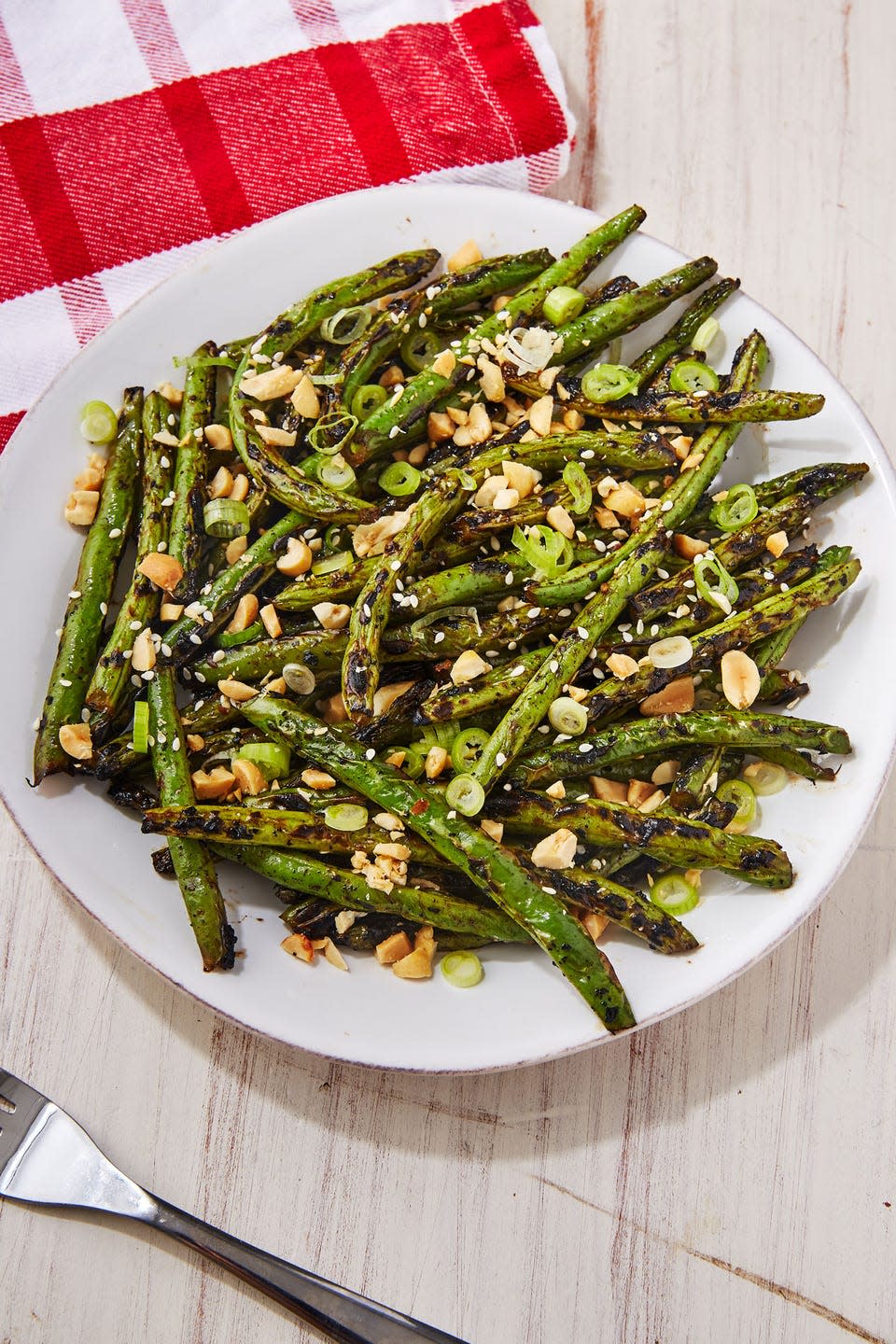 <p>If you're cooking over an actual grill, place a heavy duty piece of foil over the grates before adding the green beans. It'll prevent all the veg from falling through the cracks. Not a fan of peanuts? Use any crushed nuts or seeds here for crunch!</p><p>Get the <strong><a href="https://www.delish.com/cooking/recipe-ideas/a22243865/grilled-green-beans-recipe/" rel="nofollow noopener" target="_blank" data-ylk="slk:Grilled Green Beans recipe;elm:context_link;itc:0;sec:content-canvas" class="link ">Grilled Green Beans recipe</a></strong>.</p>