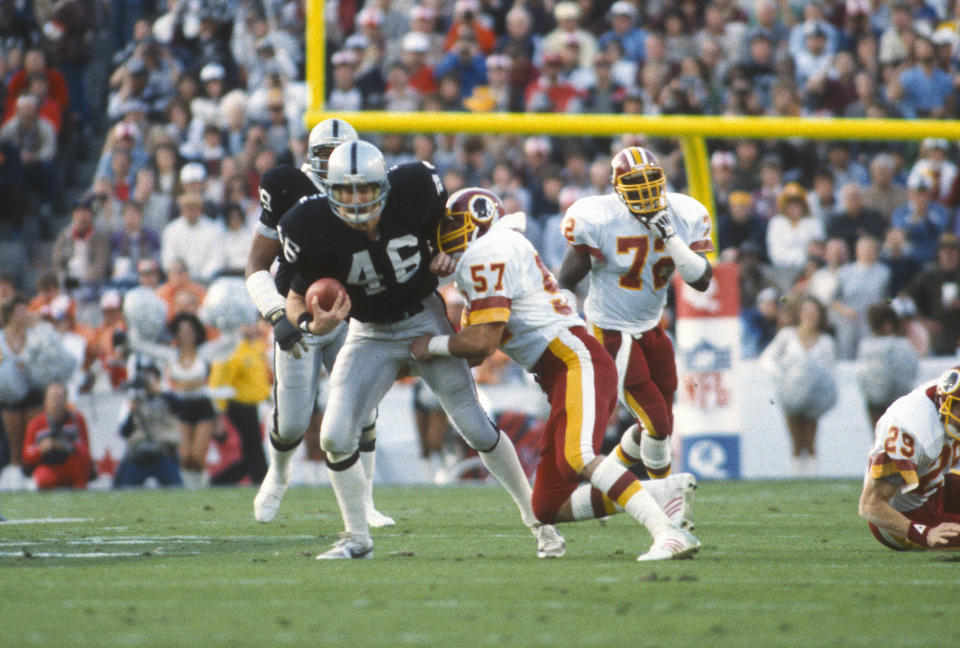 TAMPA, FL - JANUARY 22:  Todd Christensen #46 of the Los Angeles Raiders fights off the tackle of Rich Milot #57 of the Washington Redskins during Super Bowl XVIII on January 22, 1984 at Tampa Stadium in Tampa, Florida. The Raiders won the Super Bowl 38 - 9. (Photo by Focus on Sport/Getty Images)