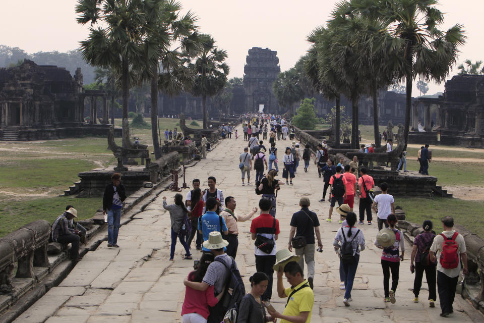 FILE - Tourists visit the Angkor Wat temple in Siem Reap, Cambodia, on March 14, 2018. The human rights group Amnesty International in a report released Tuesday Nov. 14, 2023 has strongly criticized the U.N. cultural agency UNESCO and its World Heritage program for failing to challenge the Cambodian government’s ongoing mass evictions at the world famous centuries-old Angkor Wat temple complex. (AP Photo/Heng Sinith, File)