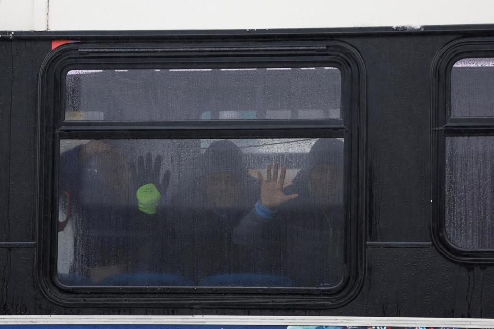 PHOTO: Migrants look through the window of a warming bus at the migrant landing zone during a winter storm, Jan. 12, 2024, in Chicago. (Kamil Krzaczynski/AFP via Getty Images)