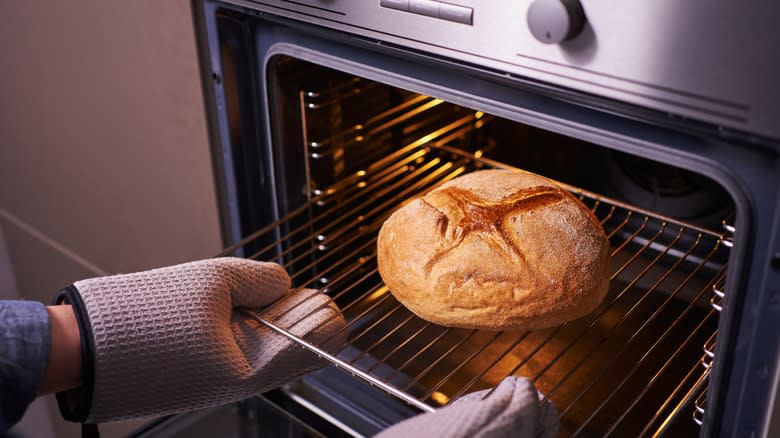baker taking bread out of oven