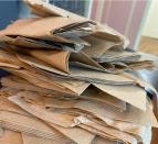 A stack of brown paper napkins with text "Alright folks... Let's see your TB napkin stash" on a wooden surface