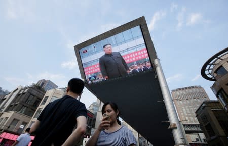 A television screen shows Chinese state media CCTV's footage of North Korean leader Kim Jong Un's meeting with Chinese President Xi Jinping in Pyongyang, in Beijing