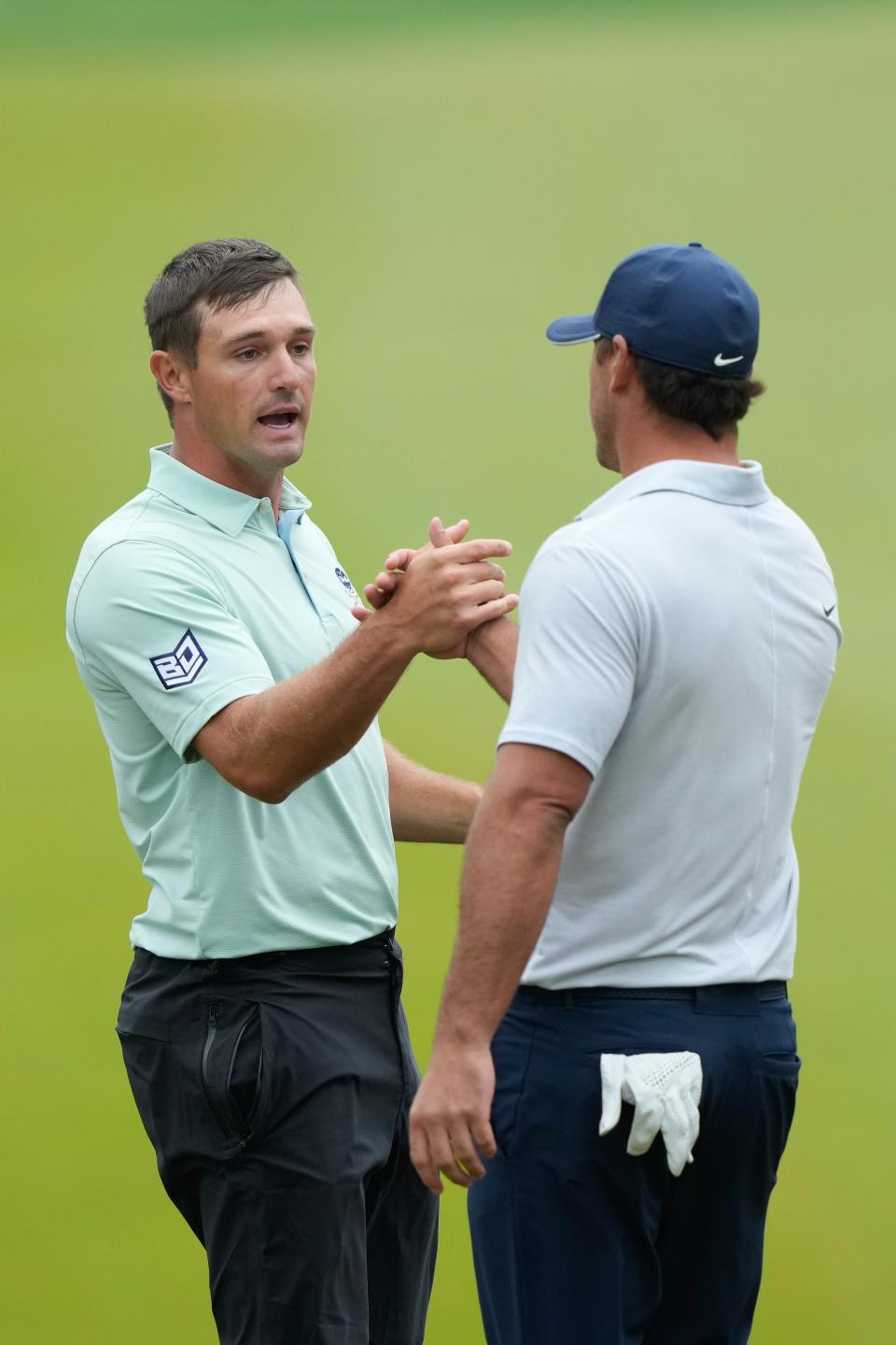Bryson DeChambeau (left) and Brooks Koepka (right) shake hands on the 18th green during the third round of the PGA Championship.