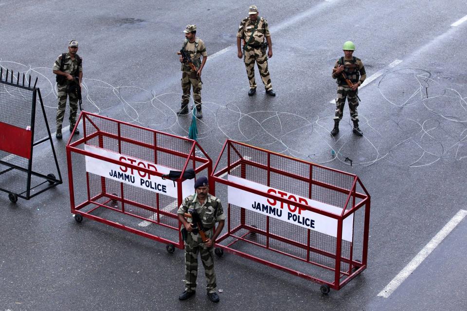 Security personnel stand guard at a roadblock in Jammu on August 7. A protester died after being chased by police during a curfew in Kashmir's main city, left in turmoil by an Indian government move to tighten control over the restive region, a police official said on August 7. | RAKESH BAKSHI—AFP/Getty Images