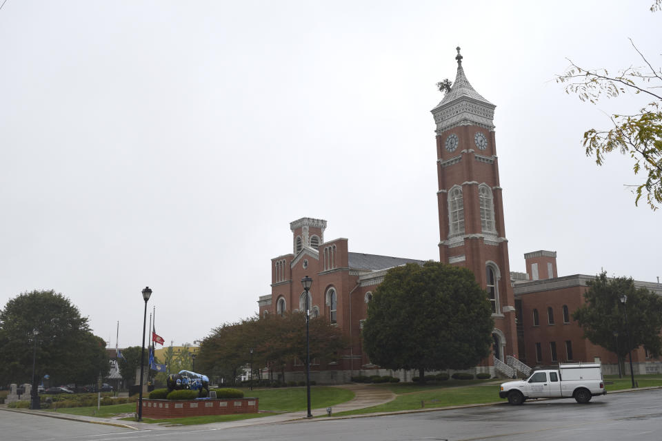 This Friday Oct. 22, 2021 photo shows the Decatur County courthouse in Greensburg, Ind. Located 50 miles southeast of Indianapolis, Greensburg will offer $5,000 to people who relocate there, in addition to providing a free babysitting service for parents as part of a new "Grandparents on Demand" program. The city's downtown square is marked by dozens of local storefronts, and a tree growing from the Decatur County courthouse clock tower has earned Greensburg the nickname "Tree City." (Casey Smith/Report for America via AP)