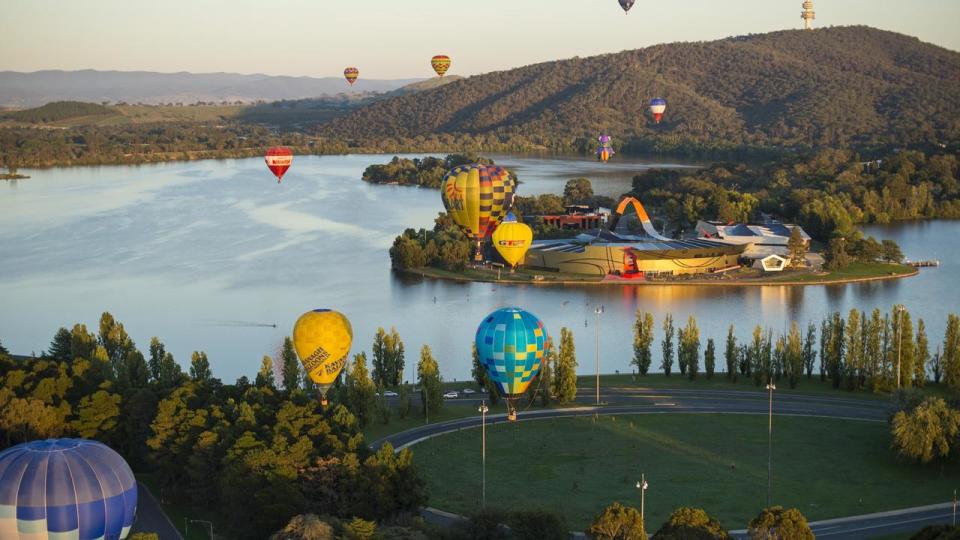 Hot air balloons drift by the National Museum of Australia in Canberra. Picture: VisitCanberra