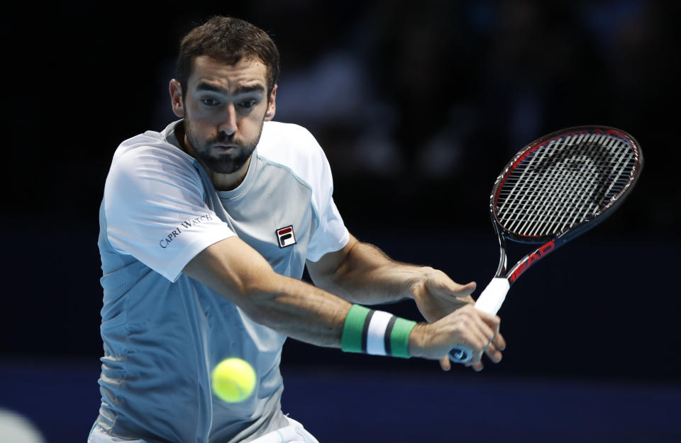 El croata Marin Cilic devuelve un tiro del estadounidense John Isner, durante su partido de la Copa Masters en la arena O2 en Londres, el miércoles 14 de noviembre de 2018. (AP Foto/Alastair Grant)