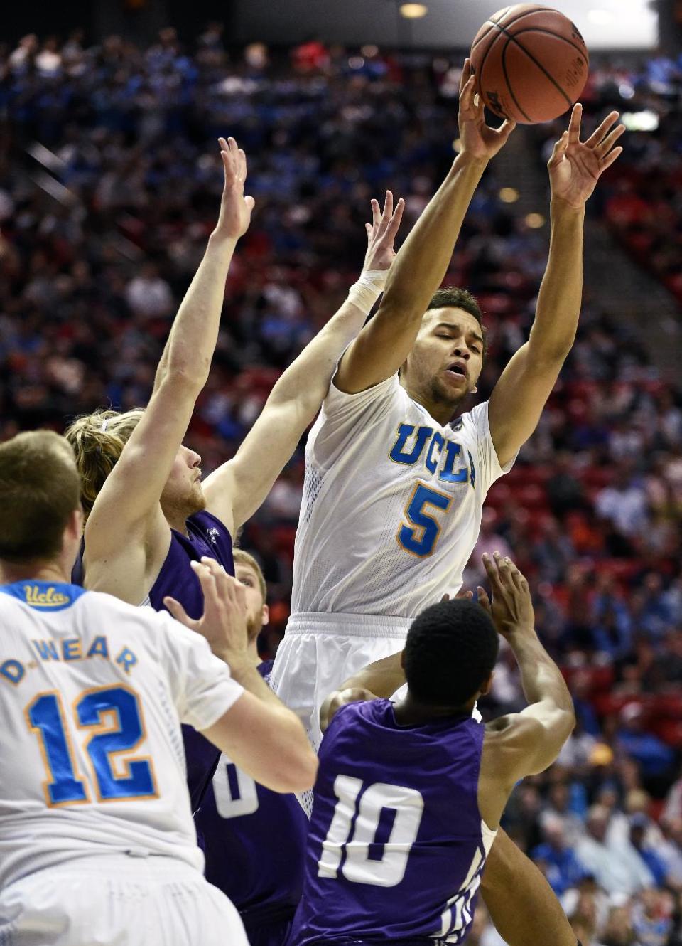 UCLA guard Kyle Anderson (5) throws an outlet pass after being confronted by Stephen F. Austin guard Trey Pinkney in a third-round game in the NCAA college basketball tournament, Sunday, March 23, 2014, in San Diego. (AP Photo/Denis Poroy)