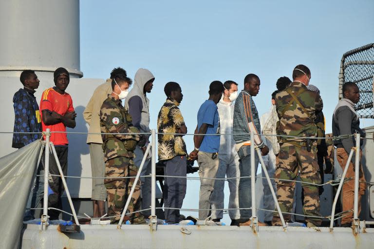 Migrants wait to disembark from the French military ship Commandant Birot after being rescued as part of the Frontex-coordinated Operation Triton off the coast of the port of Crotone, southern Italy, on May 3, 2015
