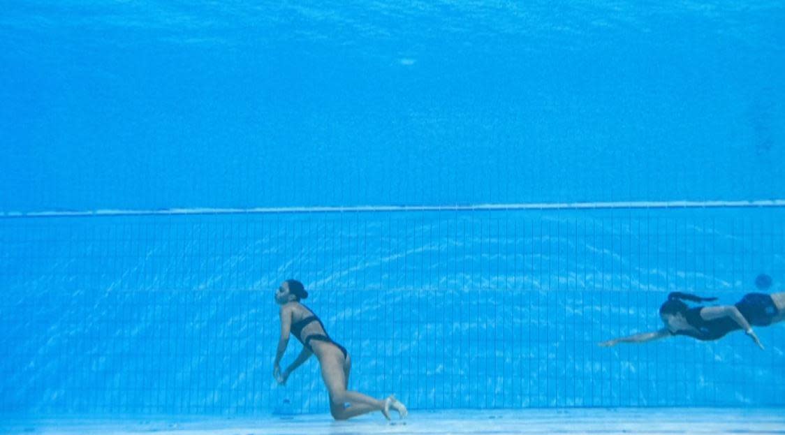 USA Artistic Swimming team member Anita Alvarez, left, hangs motionless in the water after fainting at the end of her solo routine at the World Aquatic Championships in Budapest, Hungary, June 22, 2022, as her coach Andrea Fuentes swims to the rescue. / Credit: AFP/Getty