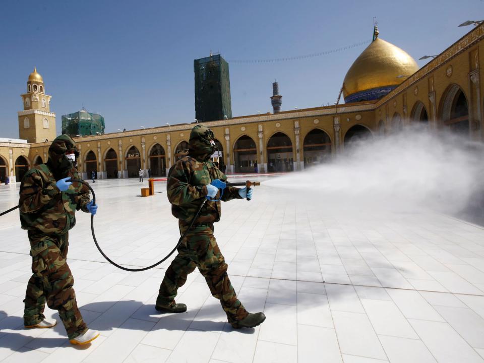 Members of the civil defense team spray disinfectant to sanitize surrounding of the Kufa mosque in the holy city of Najaf, Iraq.JPG