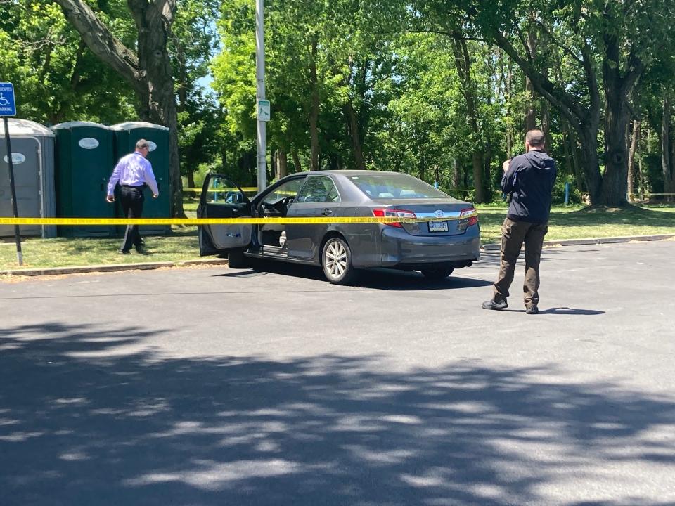 County detectives are examining a dark grey Toyota sedan parked near the shooting scene in Lions Park at the Bristol wharf on May 30, 2023.