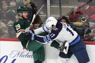 Winnipeg Jets' Adam Lowry (17) checks Minnesota Wild's Dmitry Kulikov (29) during the first period of an NHL hockey game, Friday, Nov. 26, 2021, in St. Paul, Minn. (AP Photo/Jim Mone)