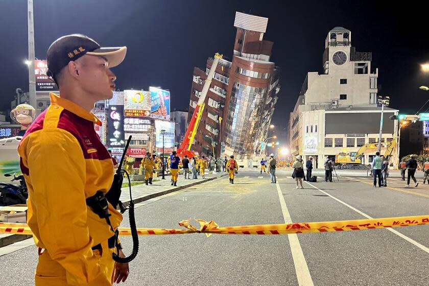 A rescue worker stands near the cordoned off site of a leaning building in the aftermath of an earthquake in Hualien, eastern Taiwan on Wednesday, April 3, 2024. Taiwan's strongest earthquake in a quarter century rocked the island during the morning rush hour Wednesday, damaging buildings and highways. (AP Photo/Johnson Lai)