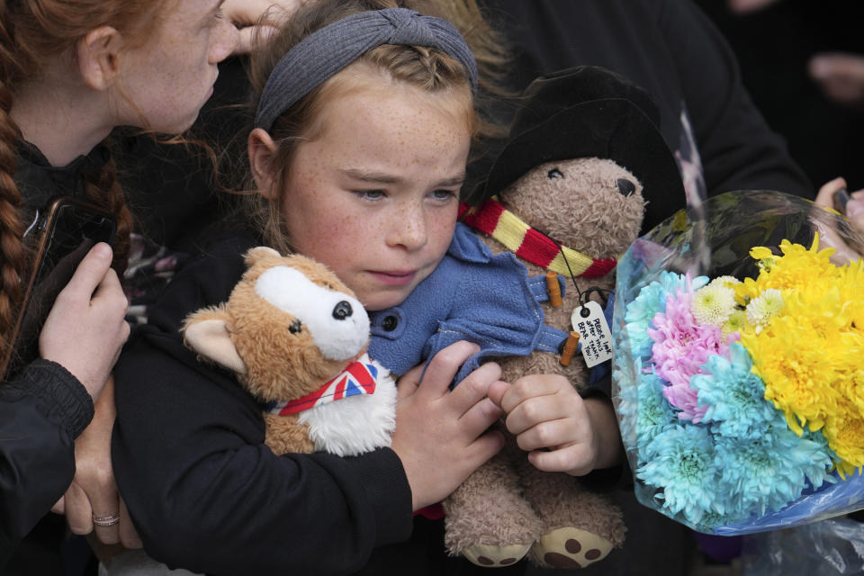 <p>A young girl holds a Paddington bear and a Corgi dog stuffed toys while waiting to watch the Procession of Queen Elizabeth's coffin from the Palace of Holyroodhouse to St Giles Cathedral on the Royal Mile in Edinburgh, Scotland, Monday, Sept. 12, 2022. At the Cathedral there will be a Service to celebrate the life of the Queen and her connection to Scotland. (AP Photo/Jon Super, Pool)</p> 