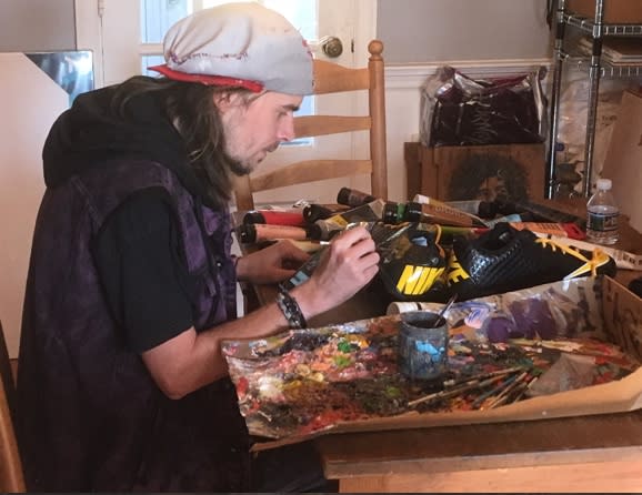 Artist Corey Pane gets to work on a pair of cleats. (Photo courtesy of Corey Pane)