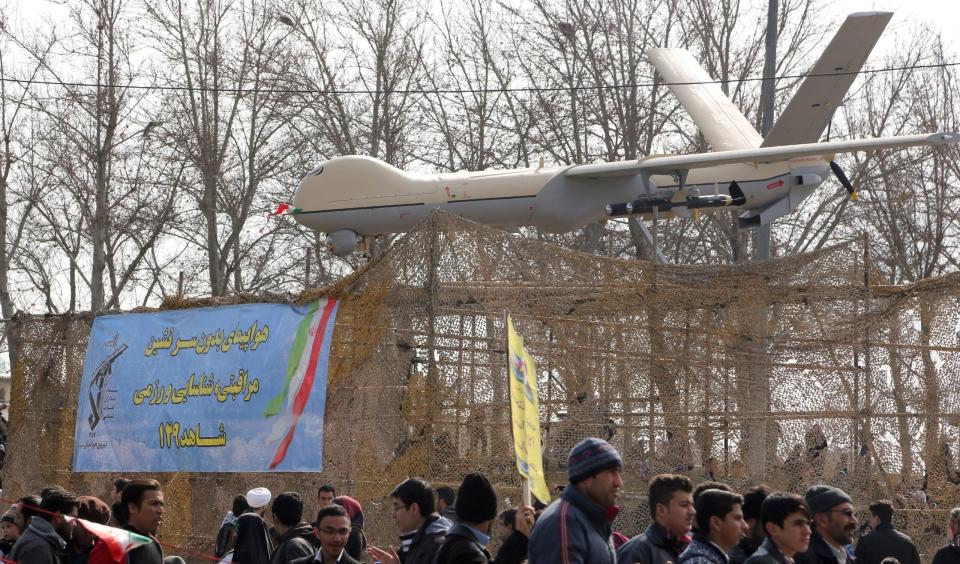 Iranians walk past a Shahed-129 drone during celebrations in Tehran to mark the 37th anniversary of the Islamic revolution on February 11, 2016. <em>Photo by ATTA KENARE/AFP via Getty Images</em>