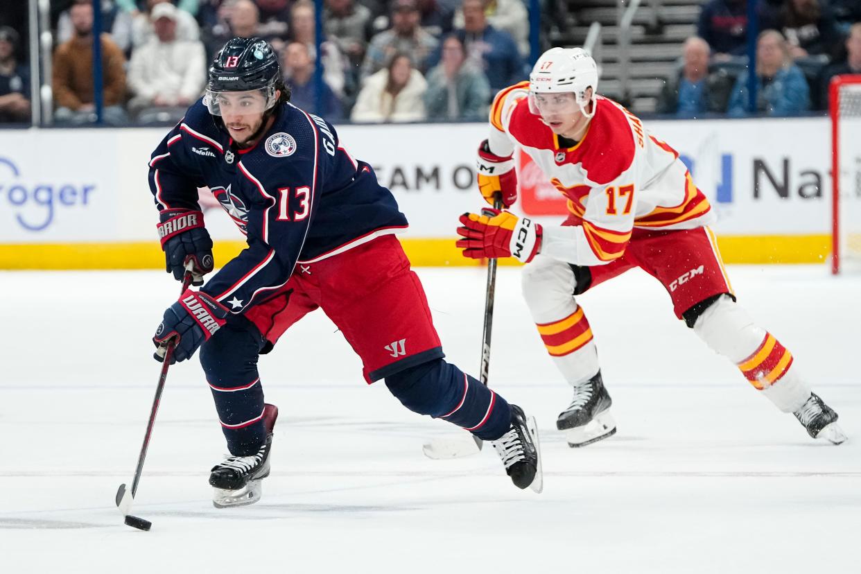 Oct 20, 2023; Columbus, Ohio, USA; Columbus Blue Jackets left wing Johnny Gaudreau (13) brings the puck up ice ahead of Calgary Flames center Yegor Sharangovich (17) during the third period of the NHL hockey game at Nationwide Arena. The Blue Jackets on 3-1.