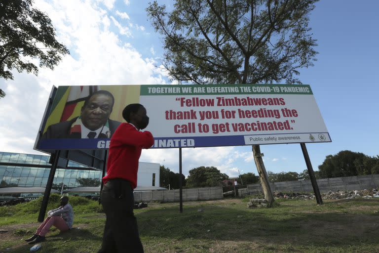 Un chico camina junto a un cartel con la imagen del presidente de Zimbabwe,  Emmerson Mnangagwa. El sur de África está en la mira por el brote de ómicron