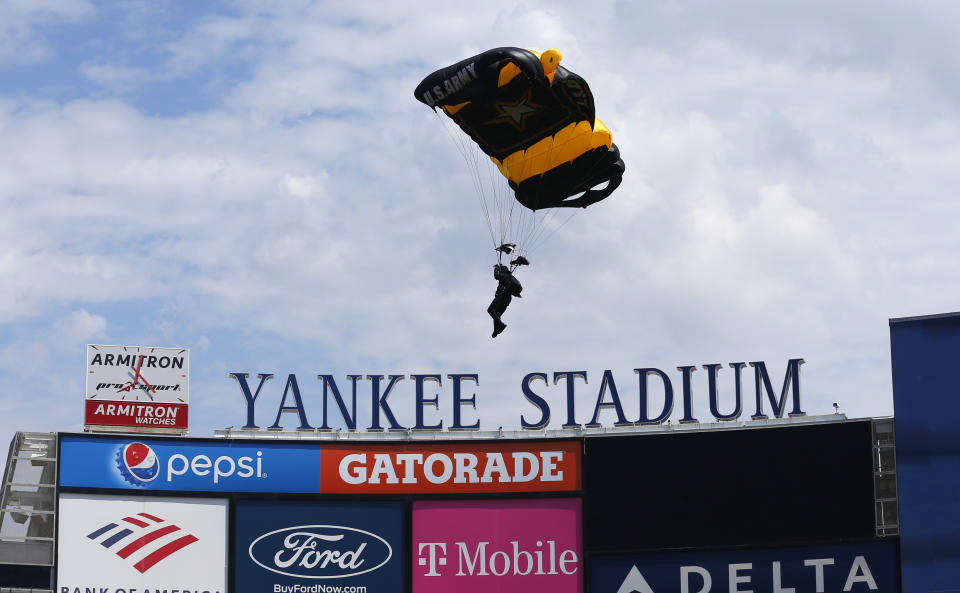 Paracaidistas del ejército de Estados Unidos descienden en el Yankee Stadium previo al juego entre los Azulejos de Toronto y los Yanquis de Nueva York, el sábado 20 de agosto de 2022. (AP Foto/Noah K. Murray)