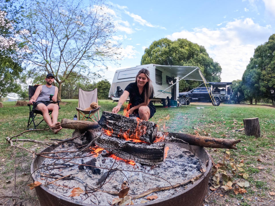 Bryce, Chelsea and their dog having a fire at a camping ground. 