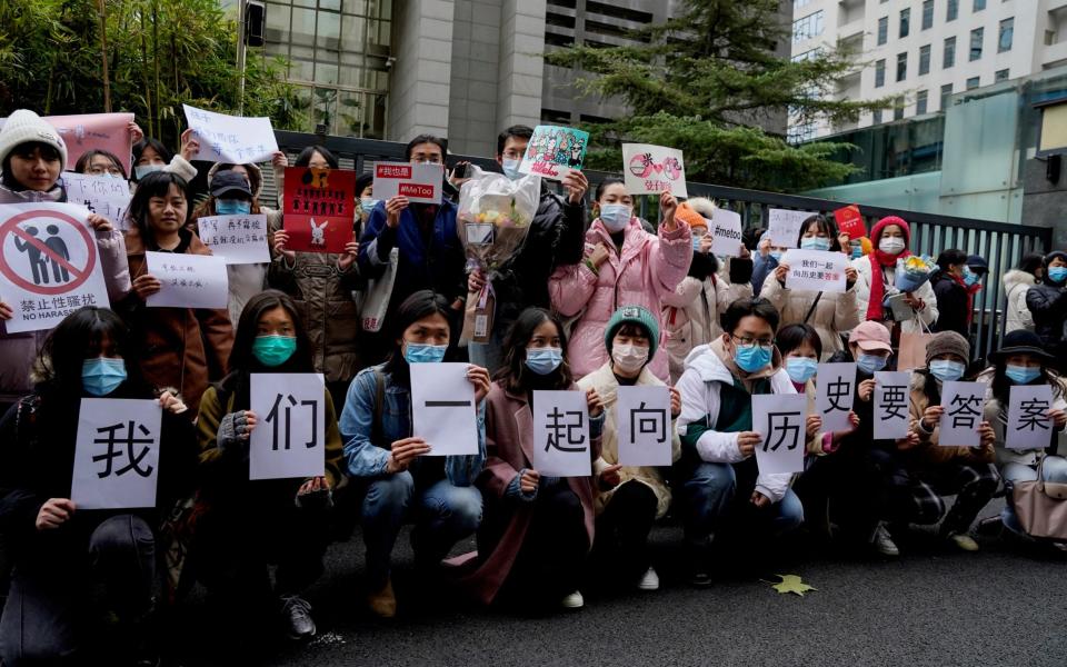 Supporters of Zhou Xiaoxuan hold banners outside at a courthouse where she is appearing in a sexual harassment case in Beijing - Andy Wong /AP